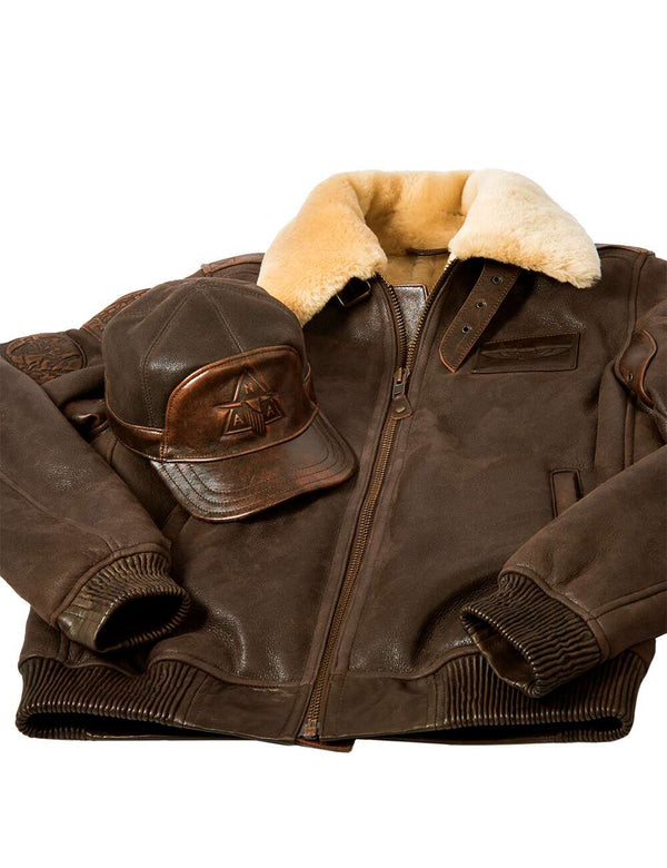 Brown leather jacket with fur collar and matching leather cap on a white background.