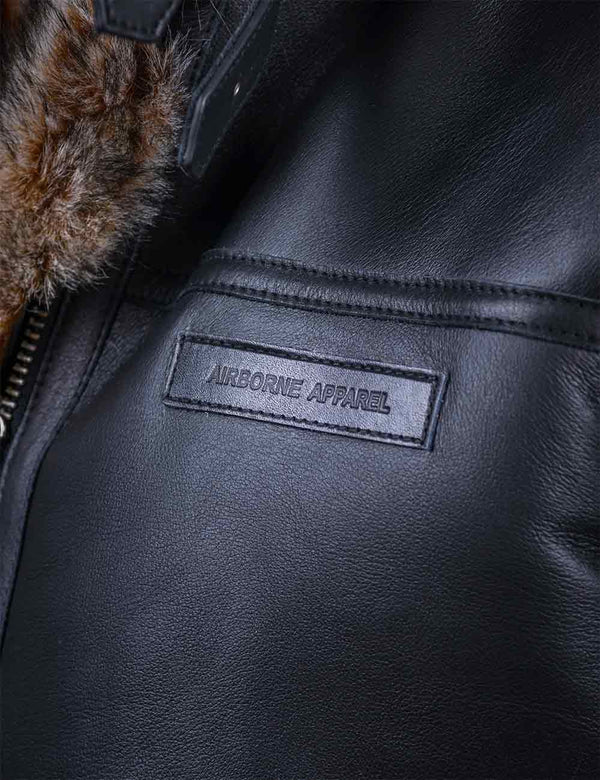 Name tag on the chest of a black leather jacket with fur.