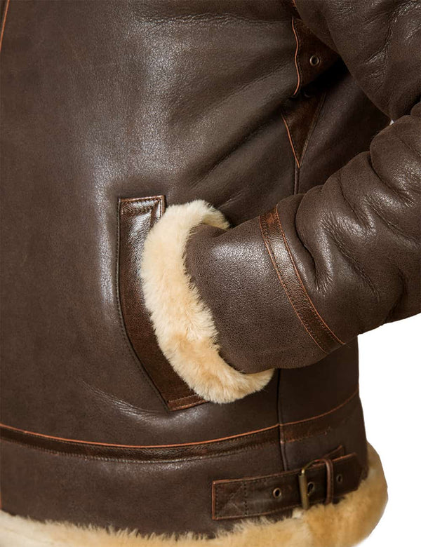 The lower left part of a men's brown sheepskin jacket, the sleeve is in the pocket.