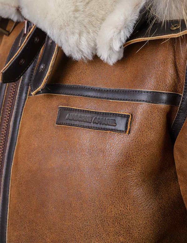 Logo patch on the chest of the orange sheepskin jacket.