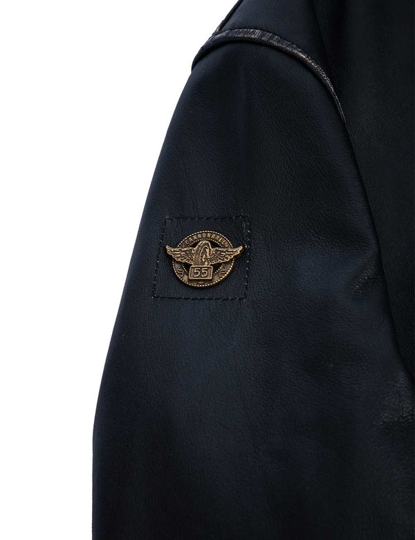 Metal badge in the form of wings in a circle on the sleeve of a men's black leather jacket.