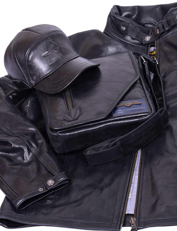 Men's black leather jacket unbuttoned, with a black leather bag and a black leather baseball cap on top.