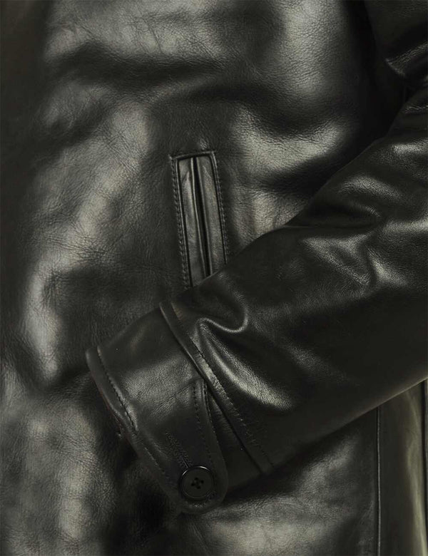 The lower part of the sleeve of a black leather jacket.