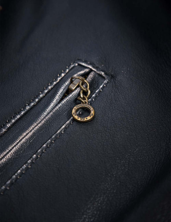 Zipper on the pocket of a black leather jacket.