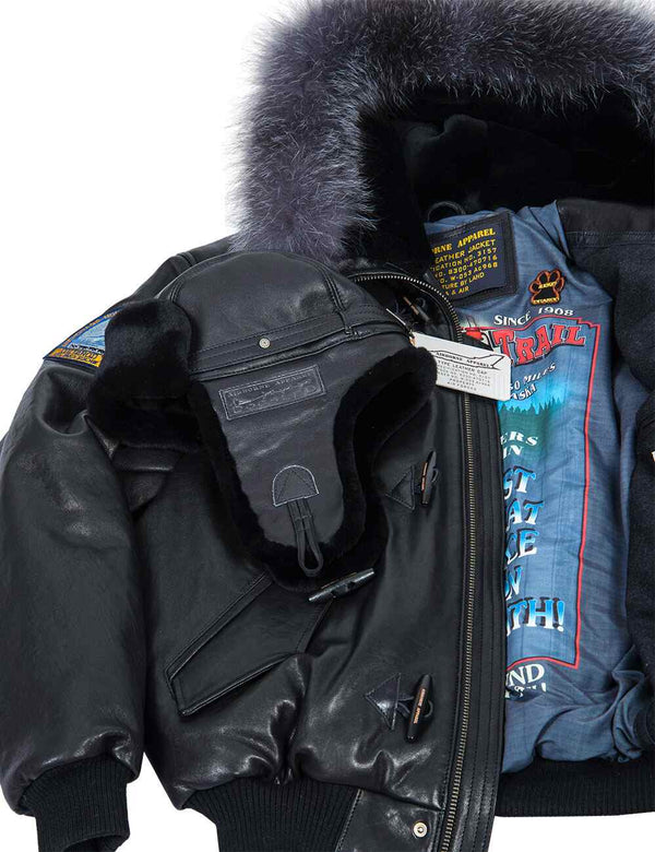 Men's black leather trapper hat placed on a black short Alaska jacket with a hood.
