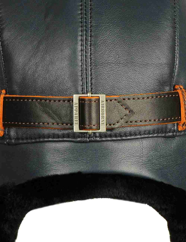 Strap with metal clasp on a navy blue leather trapper hat