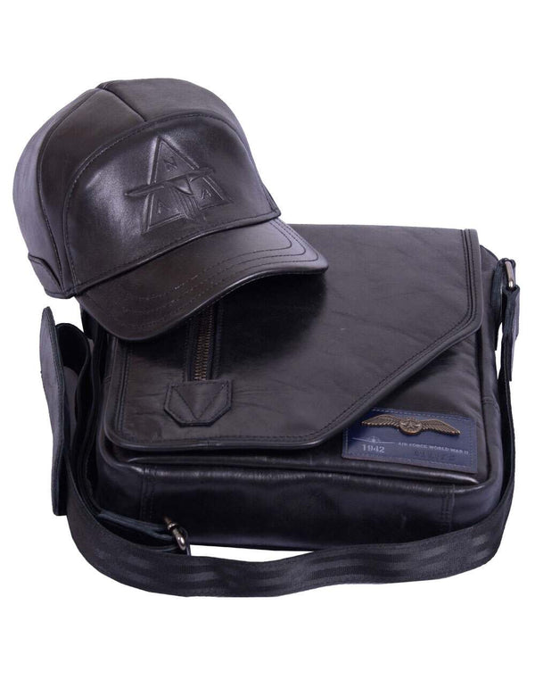 A men's black leather cap is placed on top of a men's leather bag.