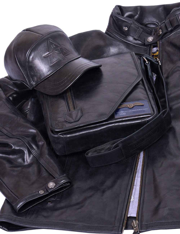 Men's black leather jacket, with a black leather cap and a men's leather bag on top.