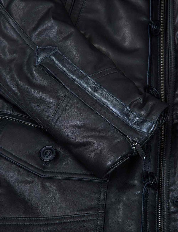 A metal zipper fastened on the sleeve of a black leather jacket.