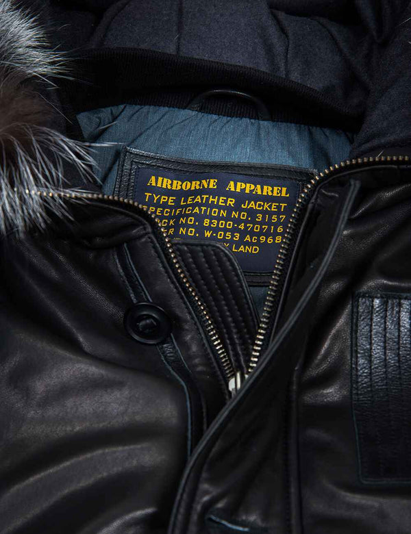 Metallic zipper on black leather jacket with hood.