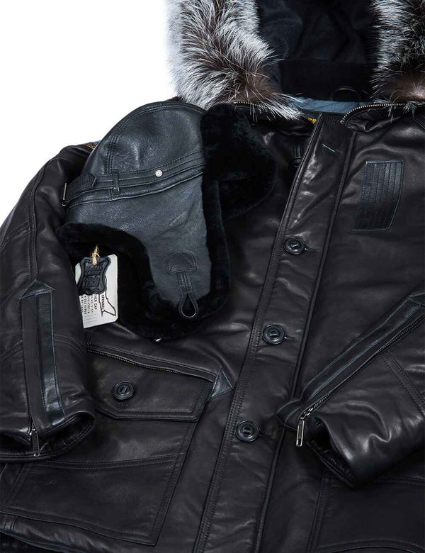 A black sheepskin ushanka hat is placed on a men's leather jacket with a fur hood.