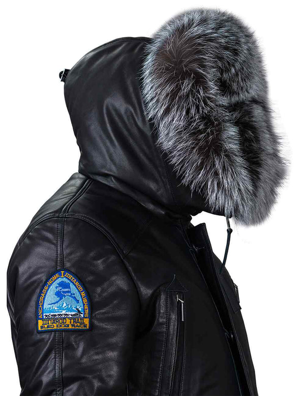 Men's black leather jacket with a hood trimmed with silver fox fur, side view.