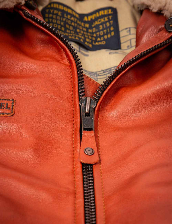Metal zipper on men's orange leather jacket.