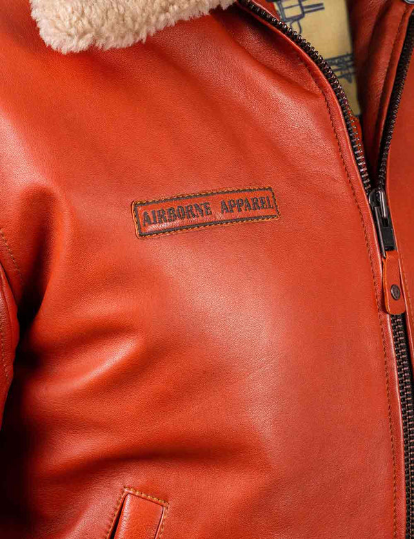 Rectangular patch with the brand logo on the chest of the orange leather jacket.