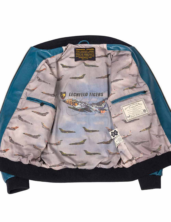A lagoon blue elasticated leather jacket, unzipped, lining with military aircraft graphics.