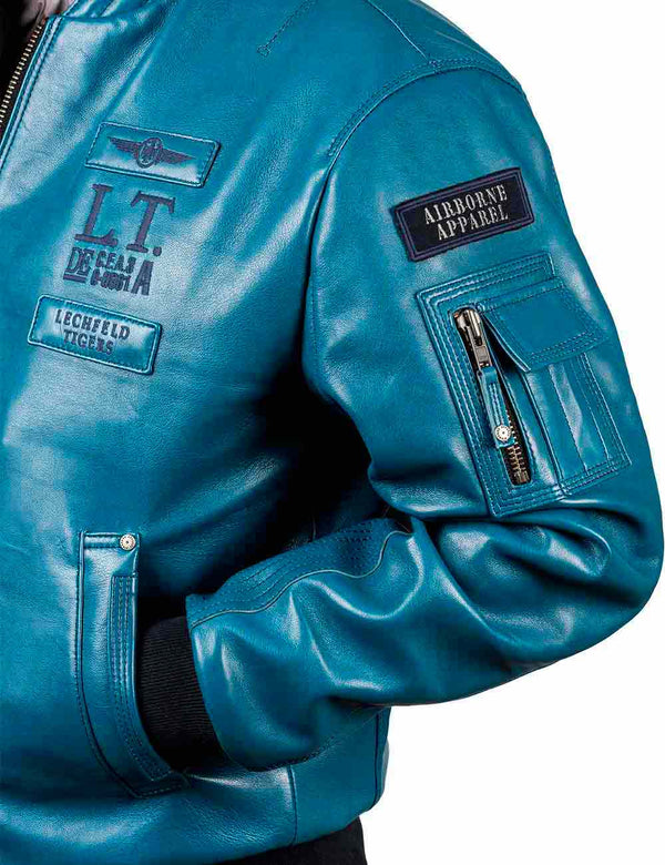 The left side of a laggon blue men's leather jacket. The sleeve with the patch and utility pocket is in the pocket.