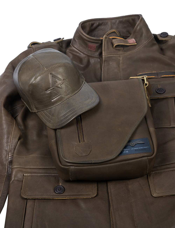 A men's olive leather bag and cap are placed on top of an olive leather jacket.
