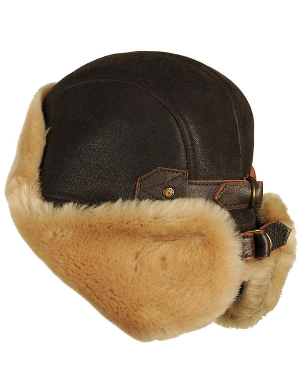 Men's brown fur hat with earflaps fastened at the back, side view.