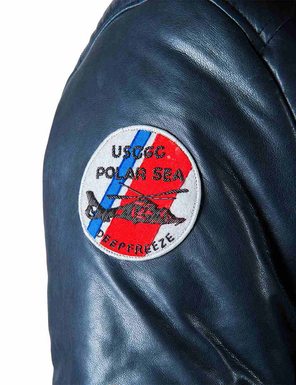 A bright patch on the sleeve of a men's blue leather parka.