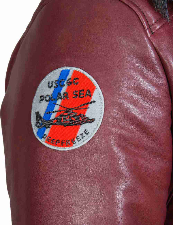 A bright patch with a helicopter image on the right sleeve of a burgundy-colored men's leather jacket.
