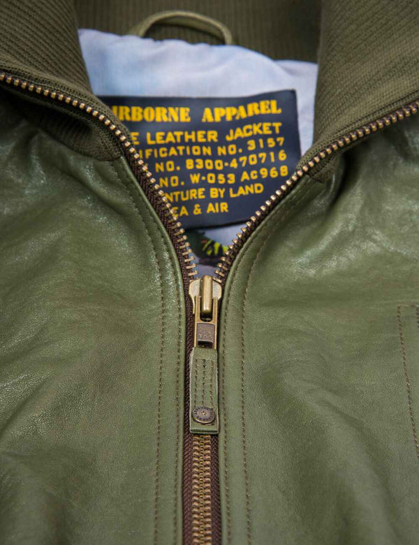 Metal zipper on a men's olive leather jacket with elastic band.