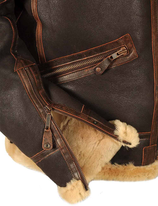 The lower right side of a men's brown sheepskin jacket, showing the sleeve with the zipper unzipped.