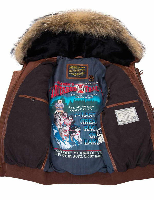 Men's light brown leather parka with raccoon fur trimmed hood, unbuttoned, revealing bright lining and interior pockets.