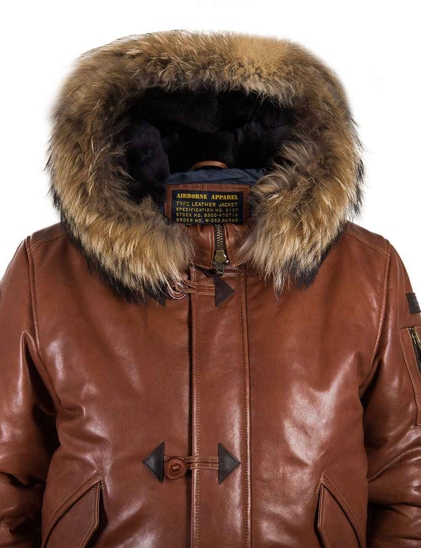 Top part of men's light brown leather parka with raccoon fur trimmed hood.