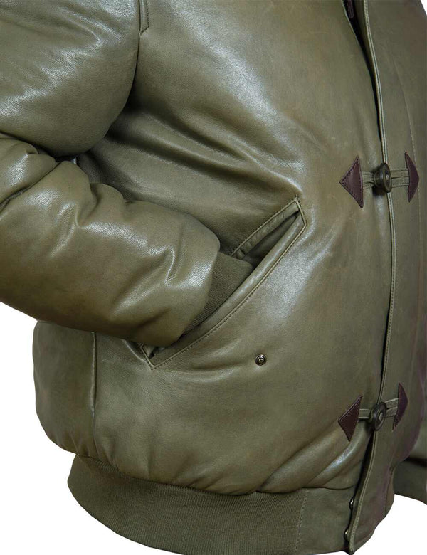 Part of an olive leather down jacket with an elastic band, sleeve in a pocket, slightly side view.