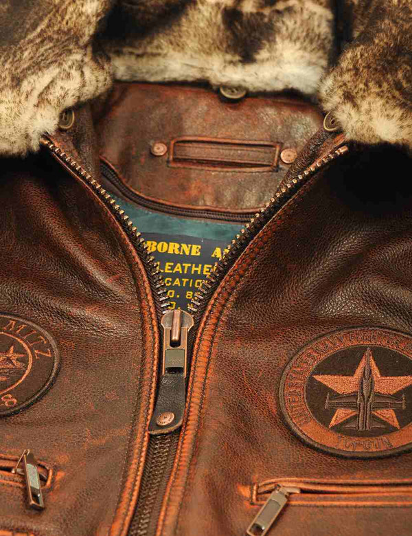 Metal zipper of a men's brown leather jacket with a fur collar.