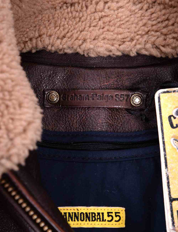 The collar section of a men's brown leather jacket with a fur collar.