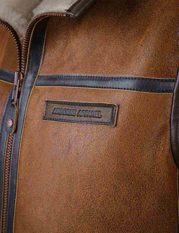 Leather name tag on the chest of a light brown men's sheepskin vest.