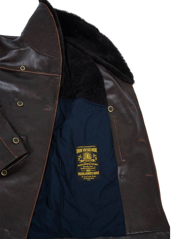 Men's brown leather jacket with fur collar unbuttoned, revealing dark blue lining and inside pocket.
