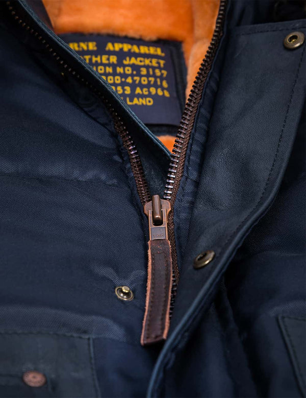 Metal zipper on a men's dark blue jacket with an orange fur lining.