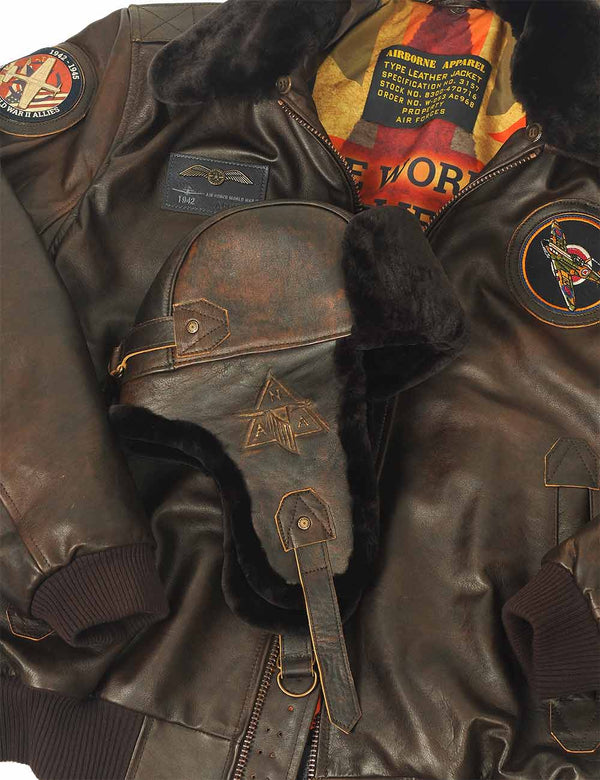 A men's brown trapper hat with a leather top and sheepskin lining is atop a brown leather jacket with bright patches and a sheepskin collar