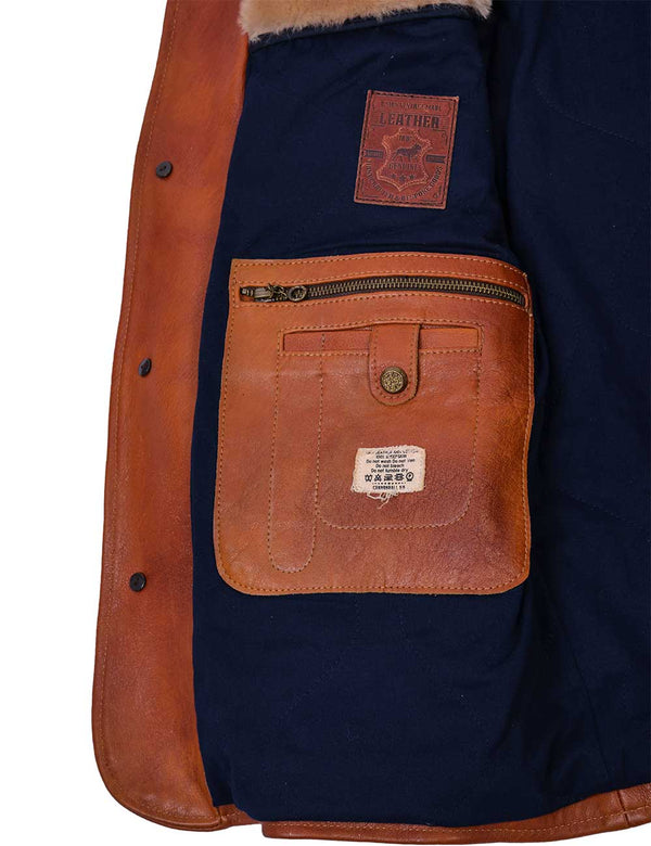 An inside pocket and dark blue lining of a men's leather jacket in light brown color.