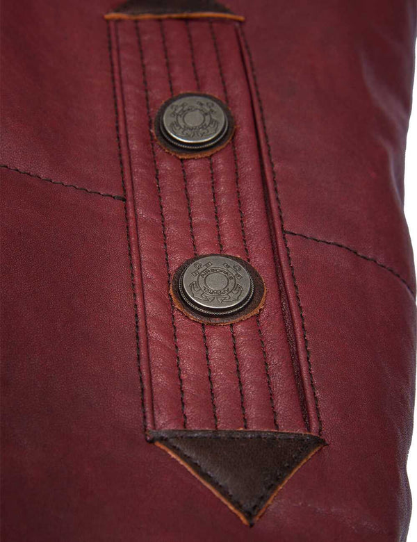 Metal buttons on the pocket of a burgundy leather men's vest.