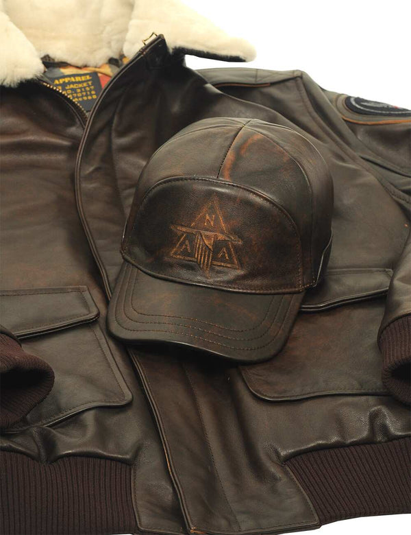 Men's brown leather cap with embossed lettering on the forehead placed on a short brown leather jacket with a cream collar