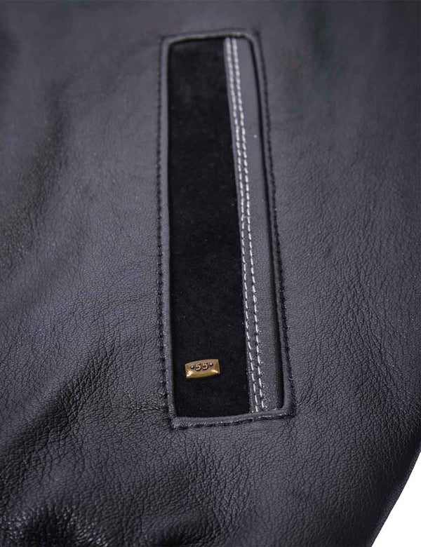 A pocket with a small metal emblem on the men's black leather jacket.