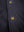 Golden buttons on a men's black leather jacket.