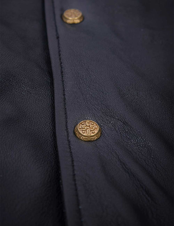 Golden buttons on a men's black leather jacket.