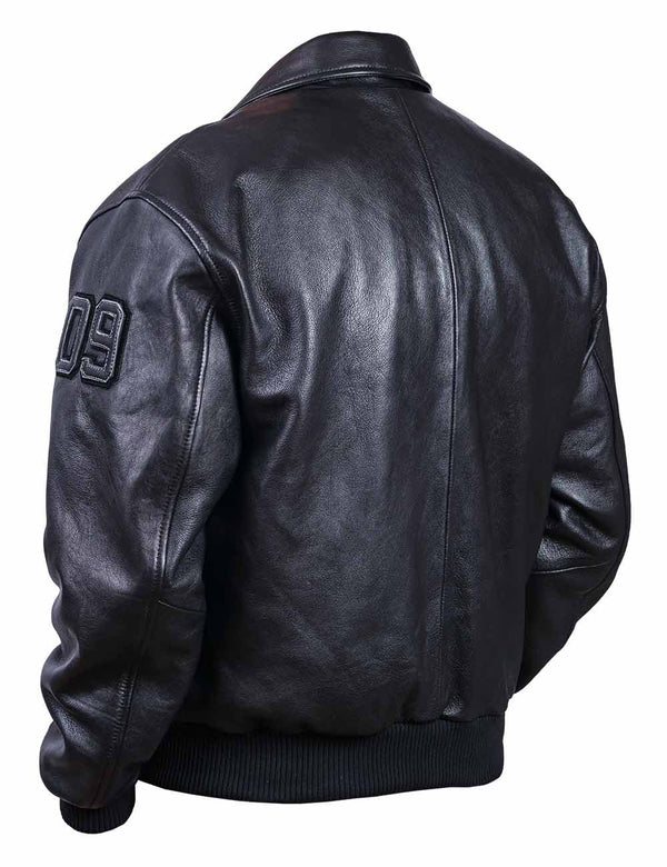 View from the back of a men's black leather jacket with an elastic band and a patch on the sleeve.