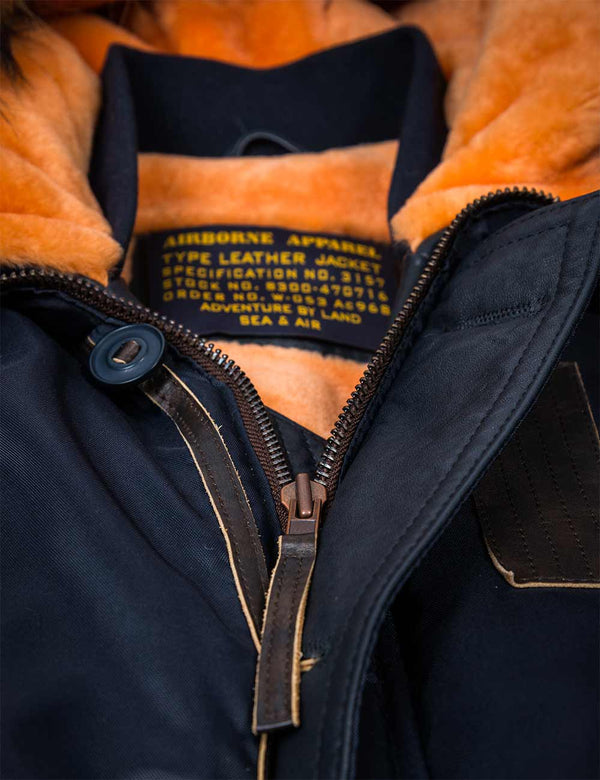 Metal zipper on a men's dark blue jacket with an orange fur lining.