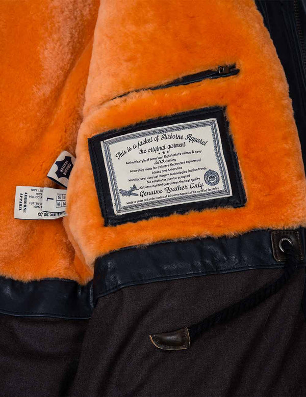 An inside pocket and a patch on fur lining of a men's navy blue jacket.