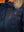 Chest pocket on a dark blue men's parka with a hood trimmed with raccoon fur.