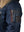 Utility pocket on the left sleeve of a dark blue men's parka with a raccoon fur trimmed hood.