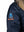 Patch on the right sleeve of a dark blue men's parka with a hood trimmed with raccoon fur.
