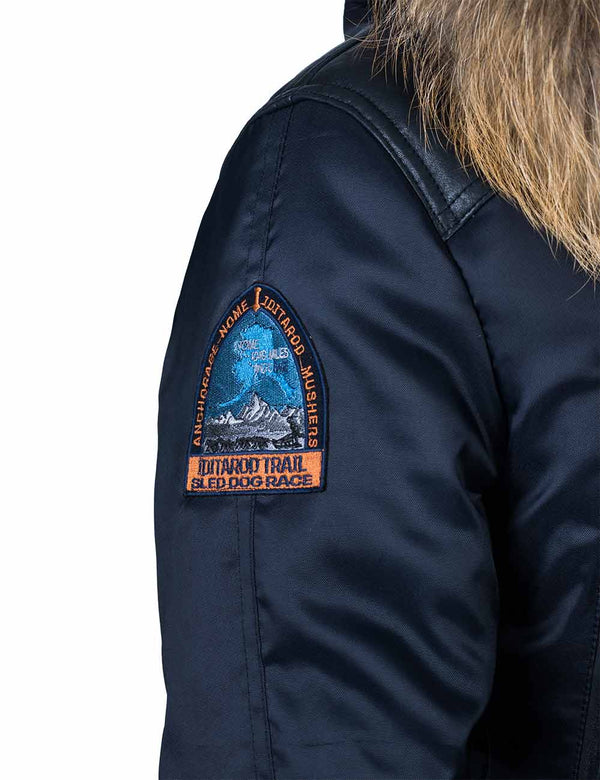 Patch on the right sleeve of a dark blue men's parka with a hood trimmed with raccoon fur.