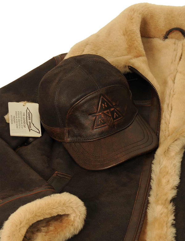 A brown men's fur cap is placed on top of a brown men's sheepskin jacket.