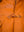 A fastened button of a men's orange leather jacket.